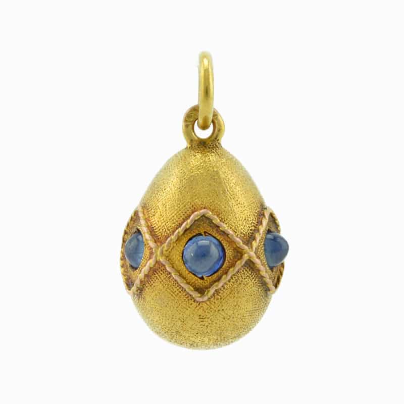A Russian gold three cabochon pale blue topaz miniature pendant egg