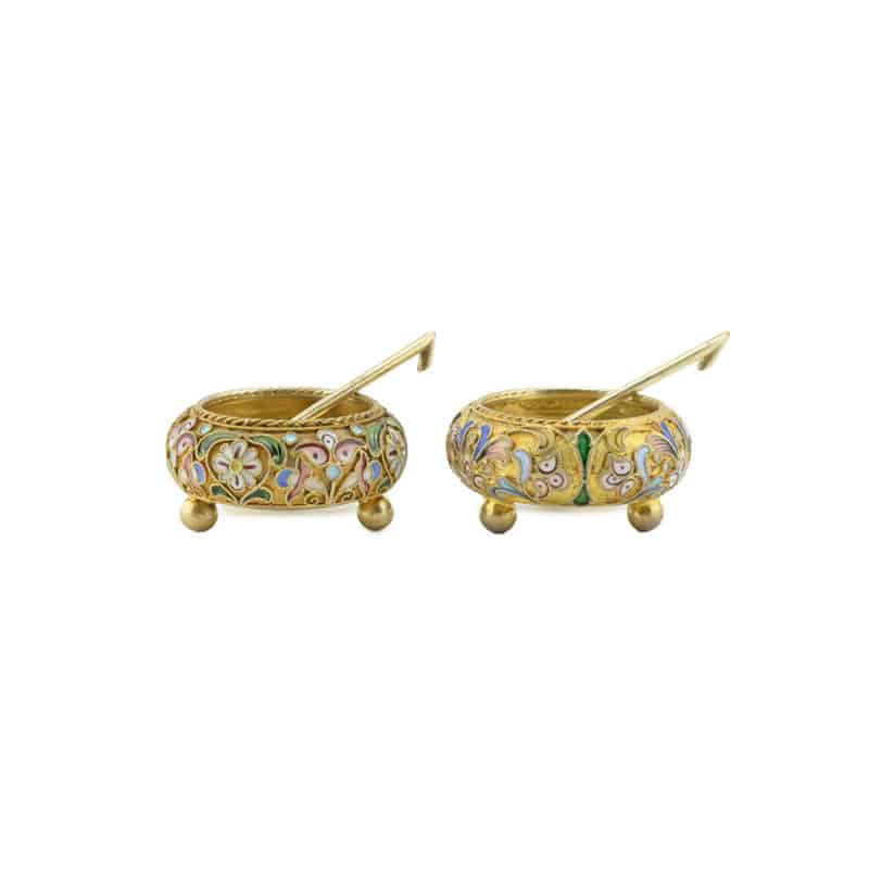 An assembled pair of Russian silver gilt and shaded cloisonné enamel open salts with two salt spoons by Feodor Rückert